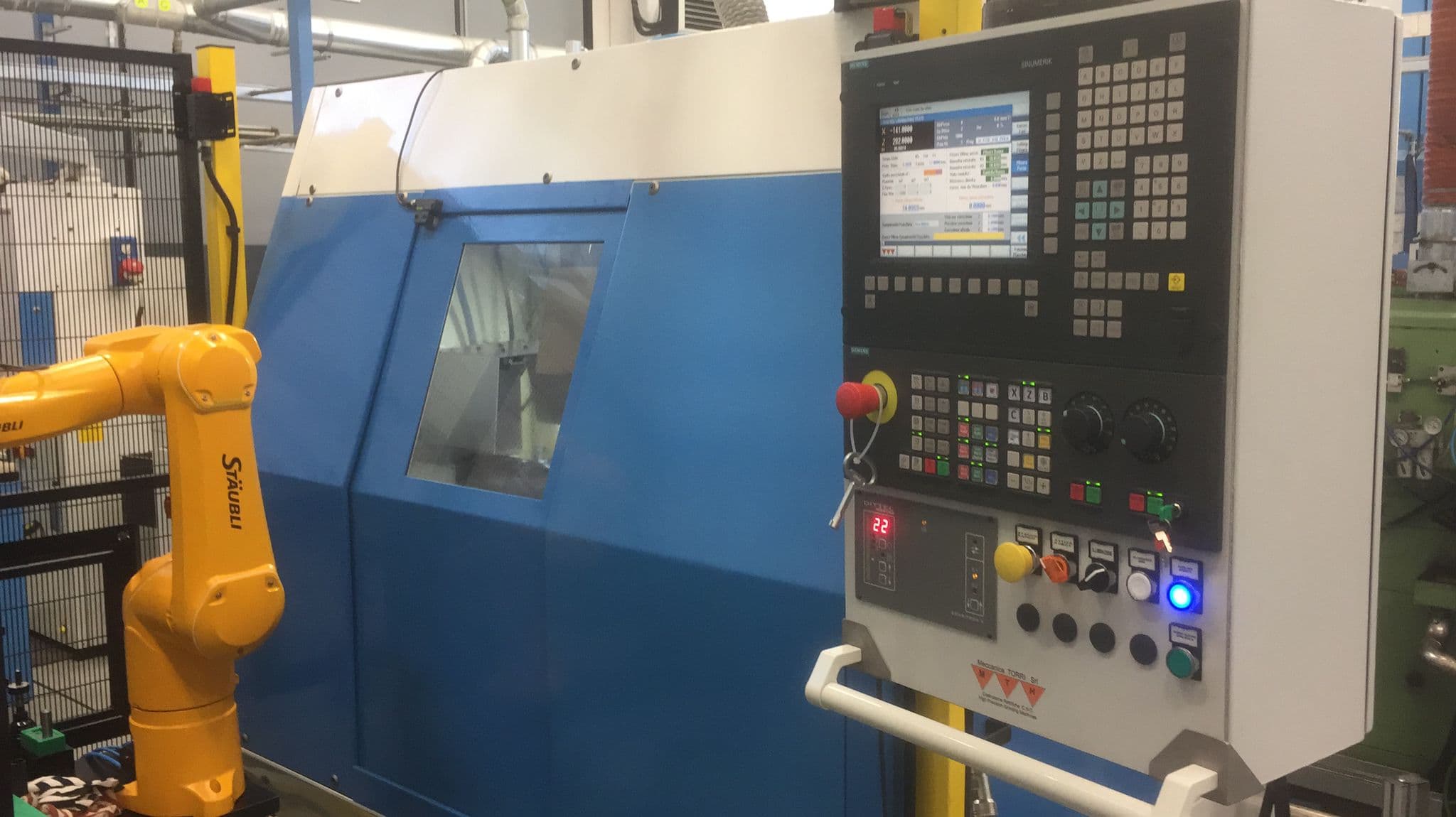 Voumard 110 CNC — vista laterale con robot di carico Stäubli e pannello Siemens